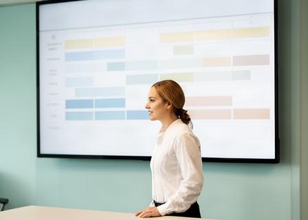 Zorgcoordinator bekijkt personeelsplanning op een groot scherm